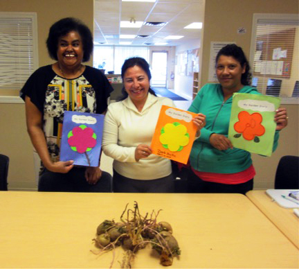 Some of the students display their garden diaries and the seed potatoes that one of the students brought in for the garden.